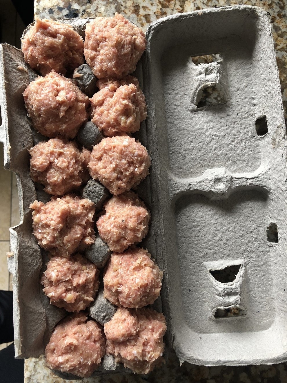 Uncooked meatballs in a cardboard egg carton