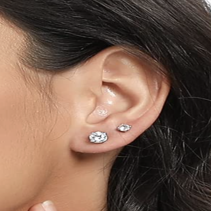 Someone wearing two of earrings on one ear, one smaller than the other