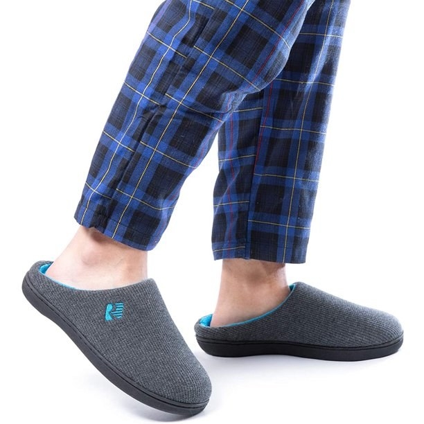 An image of a model wearing a pair of two-tone memory foam slippers