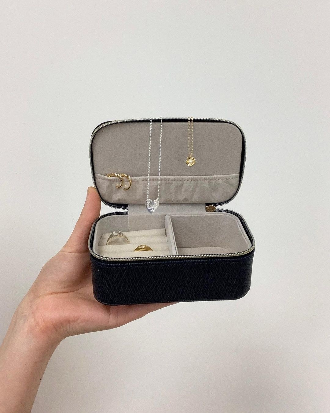 A person holding up a small rectangular jewellery case