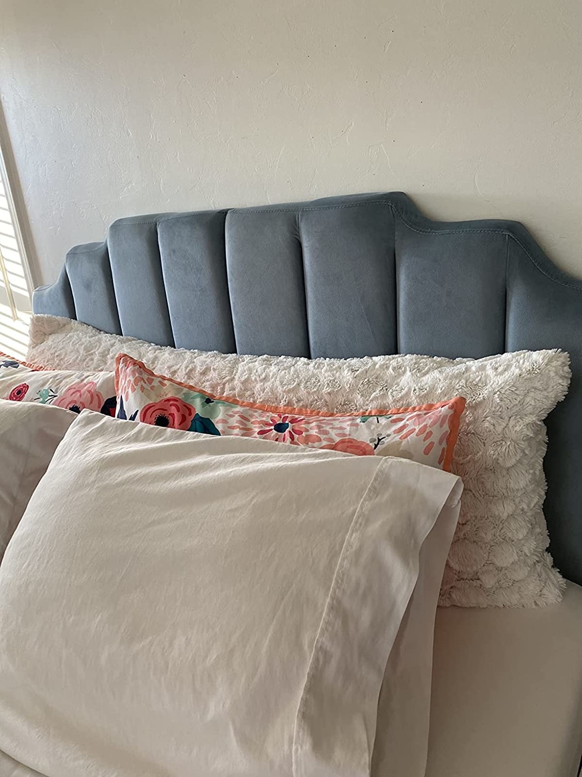 a reviewer photo of their velvet headboard in a powdered blue