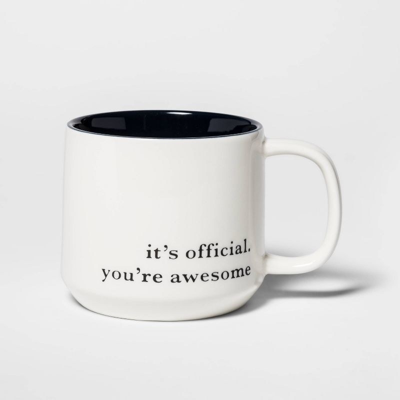 The white ceramic mug with message on it in black print