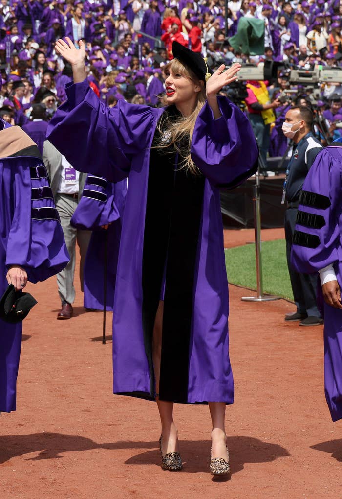 Taylor in a graduation cap and gown waving to the audience
