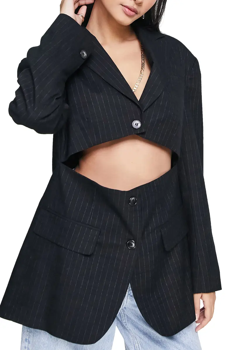 A person wearing a pinstripe blazer with a cutout across the middle