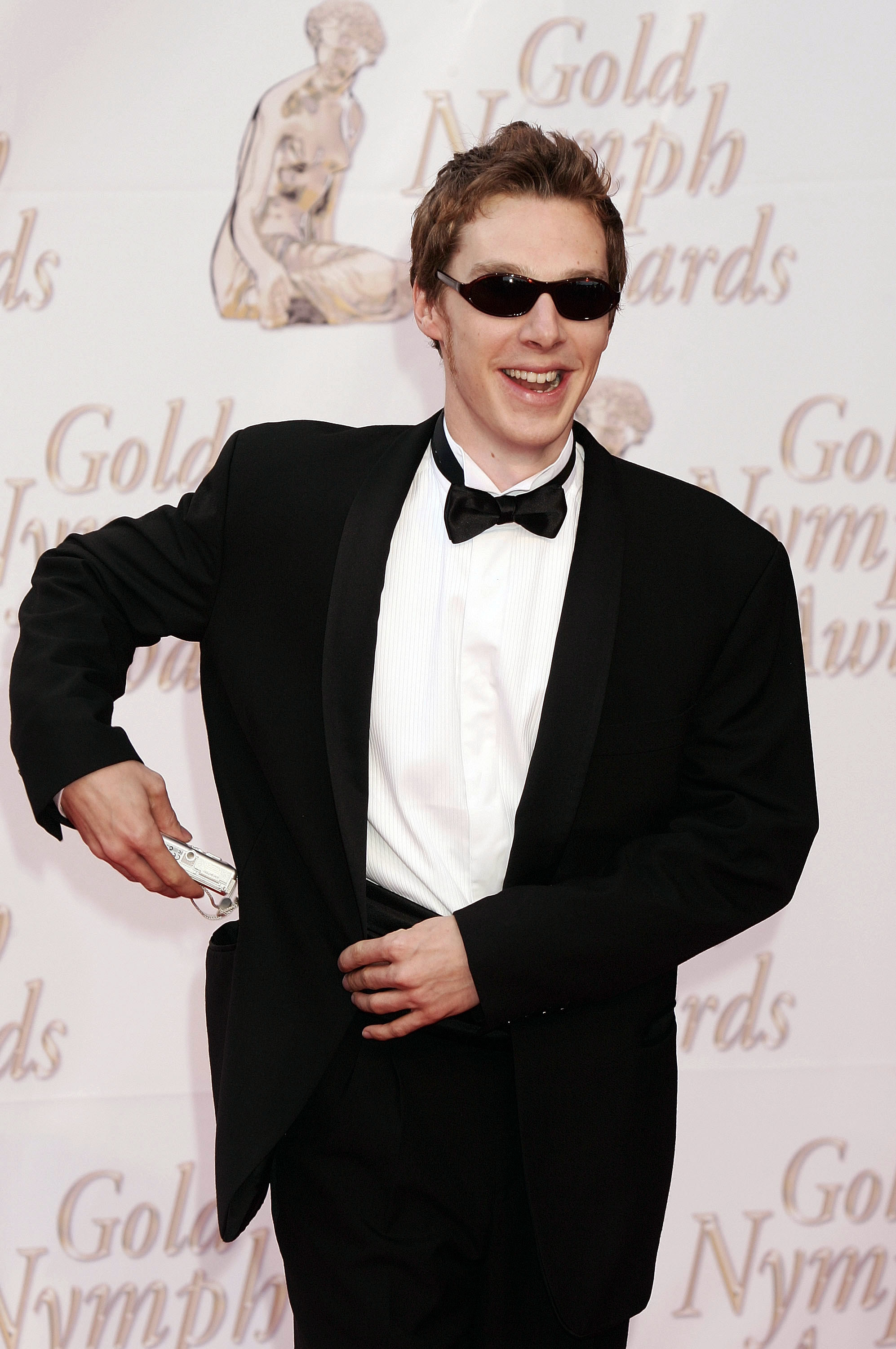 a young Cumberbatch wearing a suit and sunglasses at an event