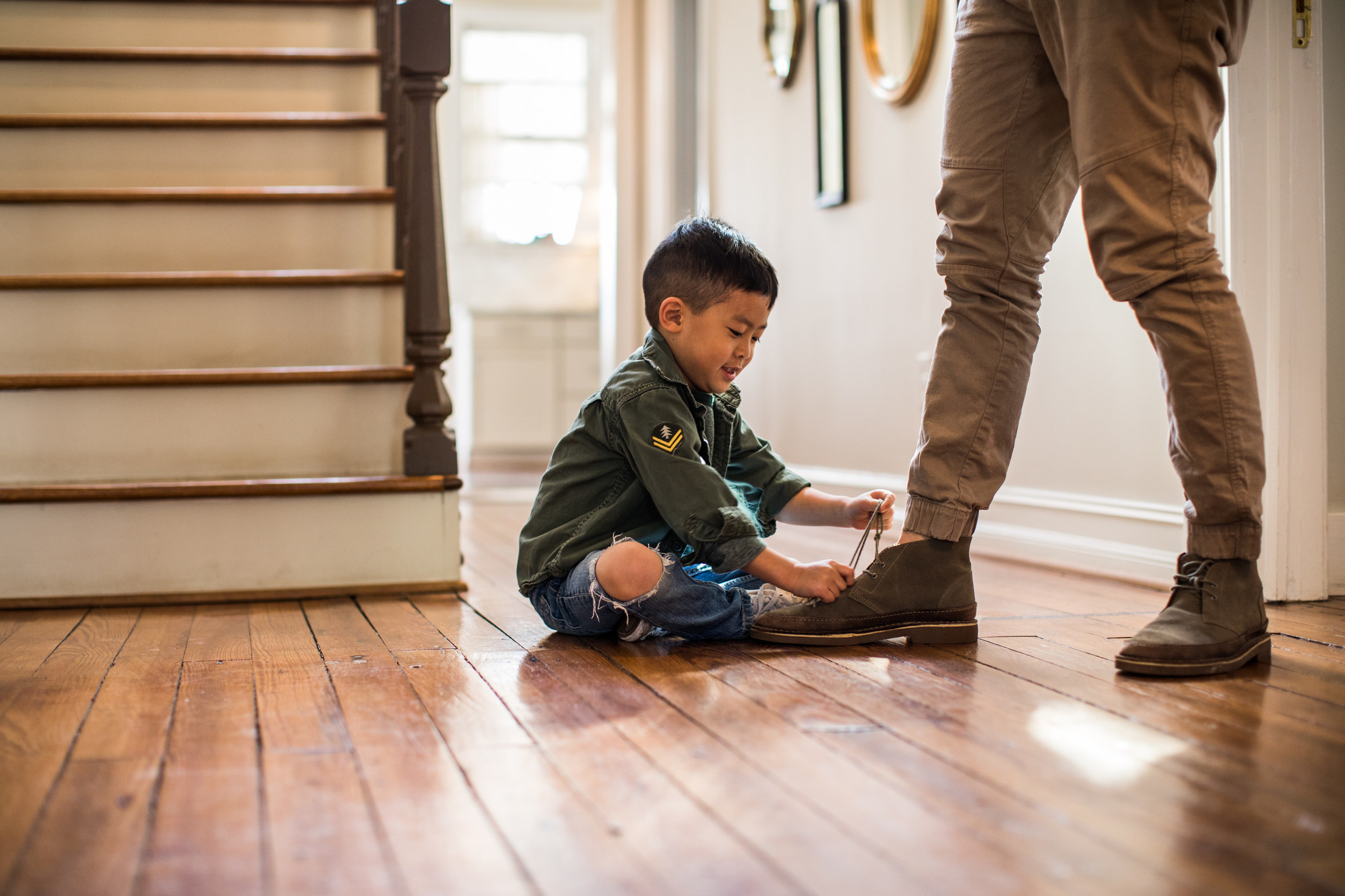 A child unlacing a person&#x27;s shoe