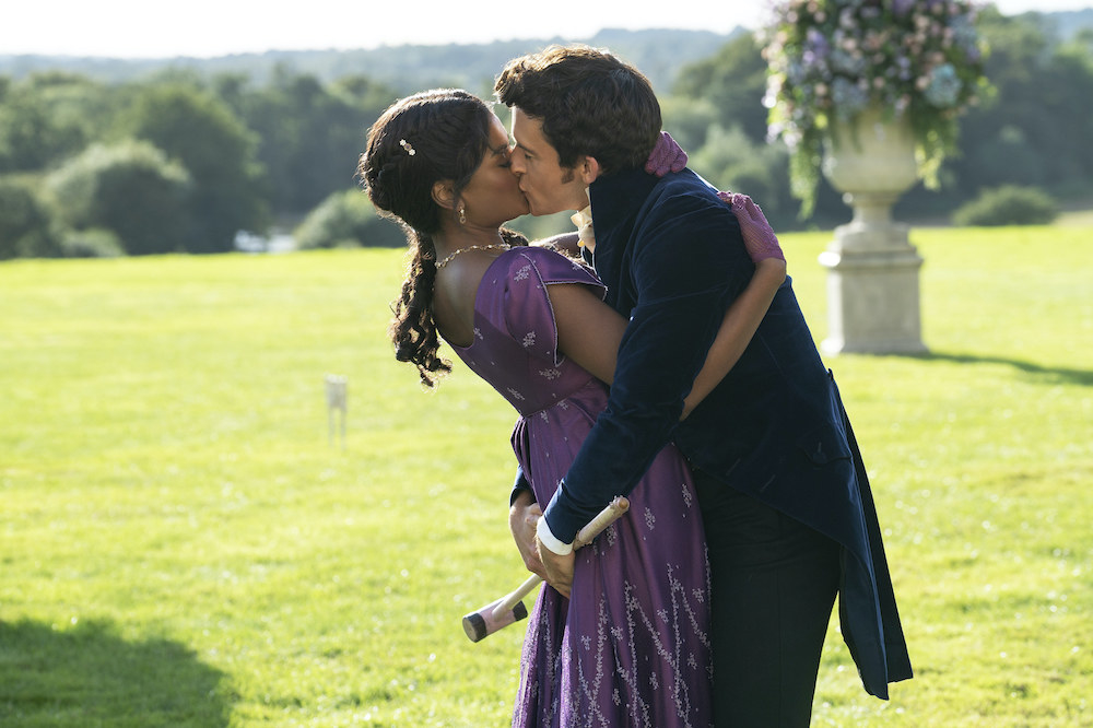 Simone and Jonathan kissing outdoors in a scene from Bridgerton