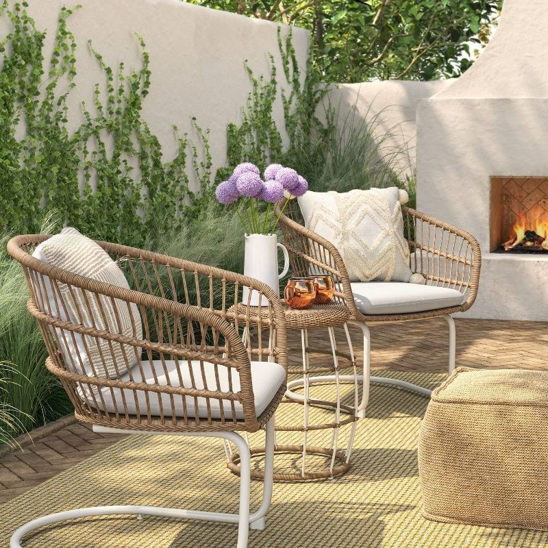 the wicker furniture with white cushions on a patio