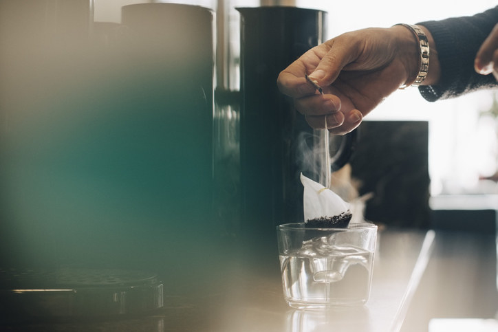 A person putting a tea bag in water