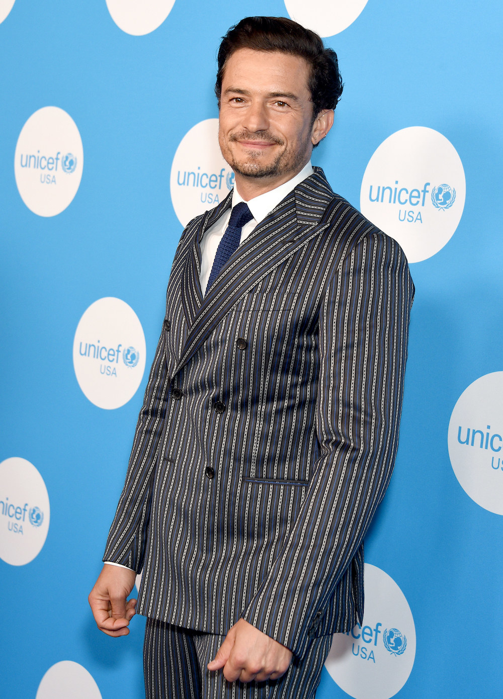 close up of Bloom in a pinstripe suit at an event