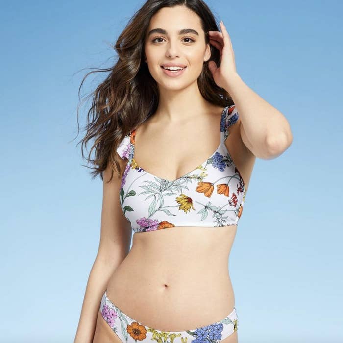 A person wearing a floral bikini top and matching bottoms