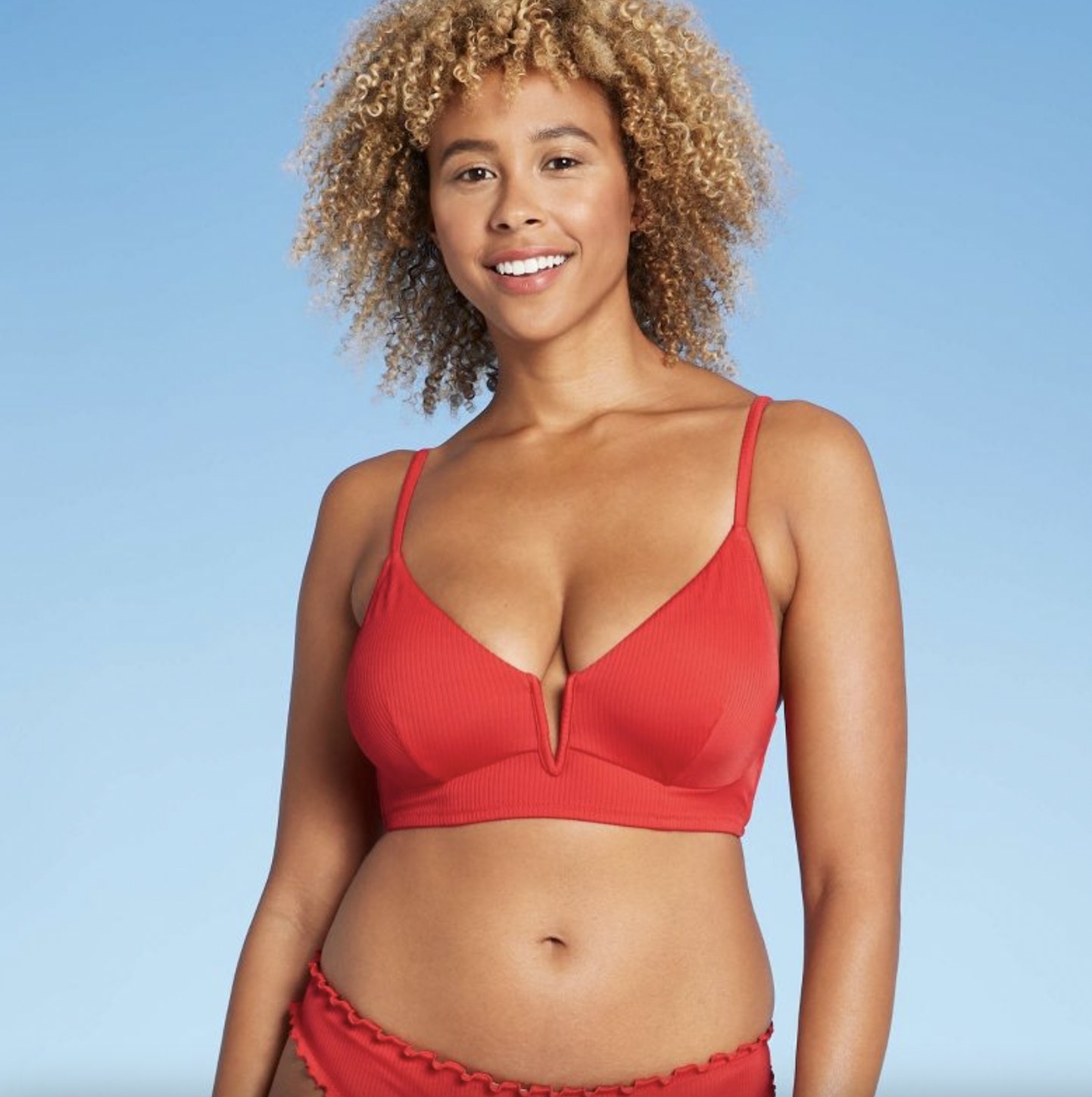 A person wearing a red bikini top with a matching bottom