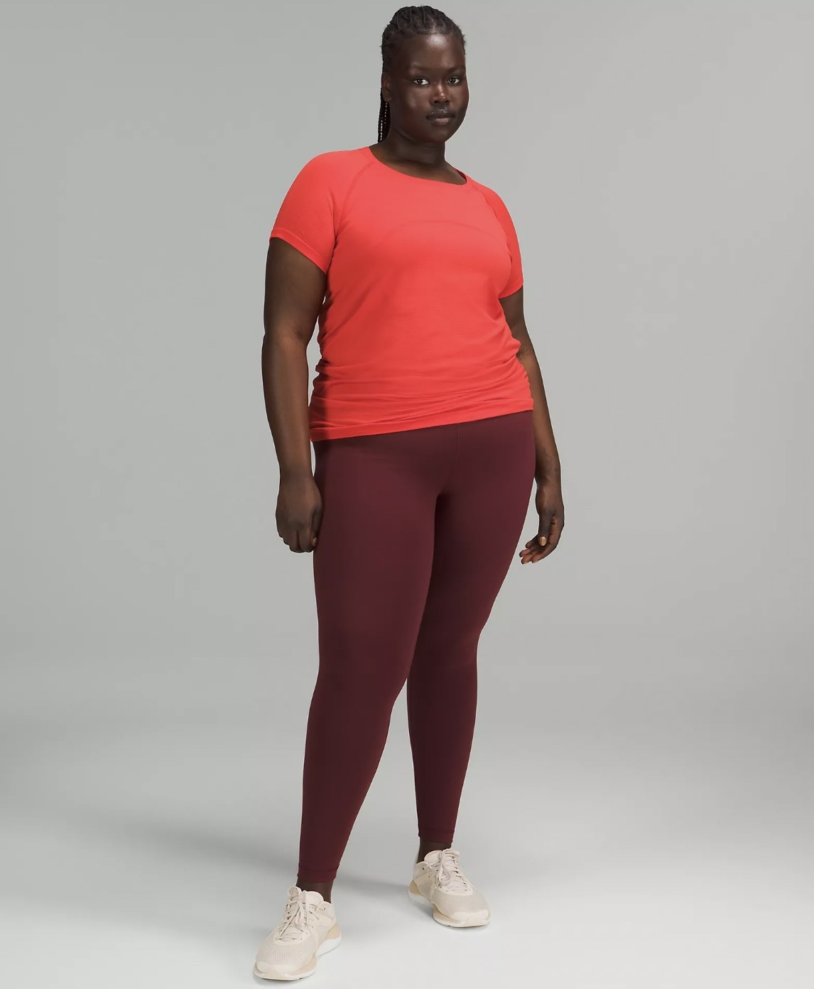 Model in the peach short sleeve with maroon leggings