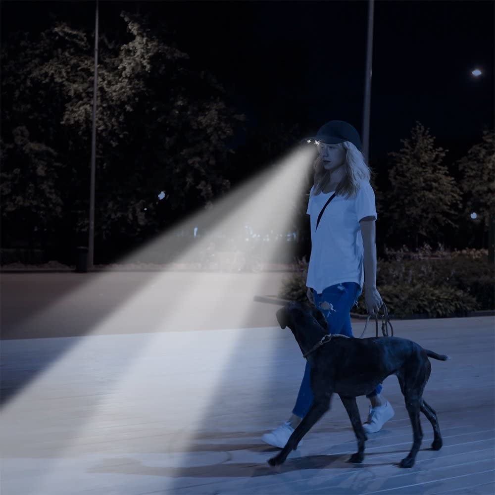 a person walking the dog while wearing the headlamp cap
