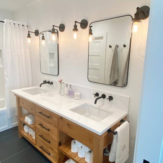a reviewer photo of two of the mirrors installed above a bathroom vanity