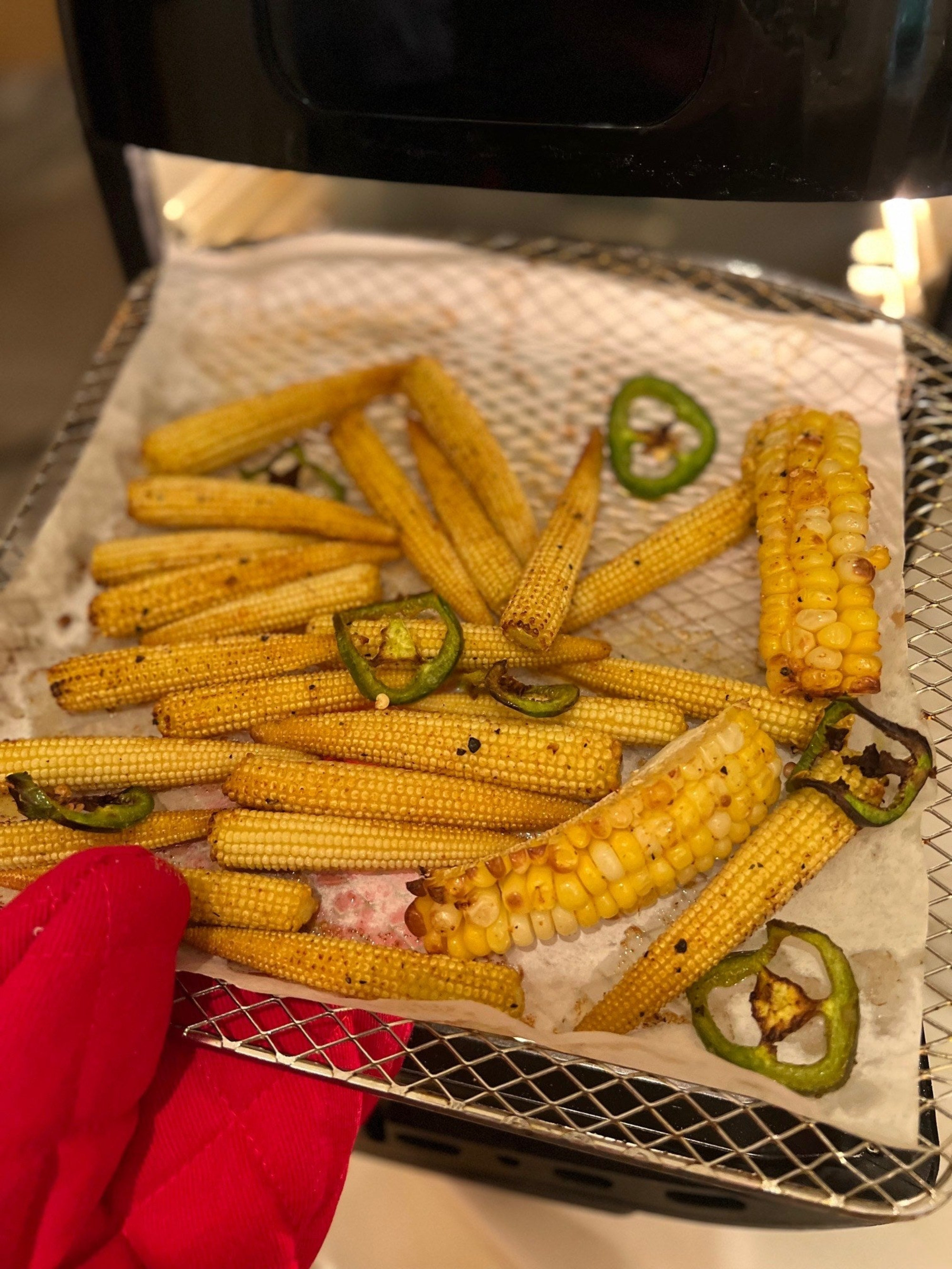 A tray topped with corn going into the air fryer