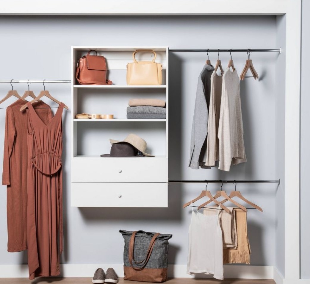 the closet organizer with clothes and accessories hanging from it