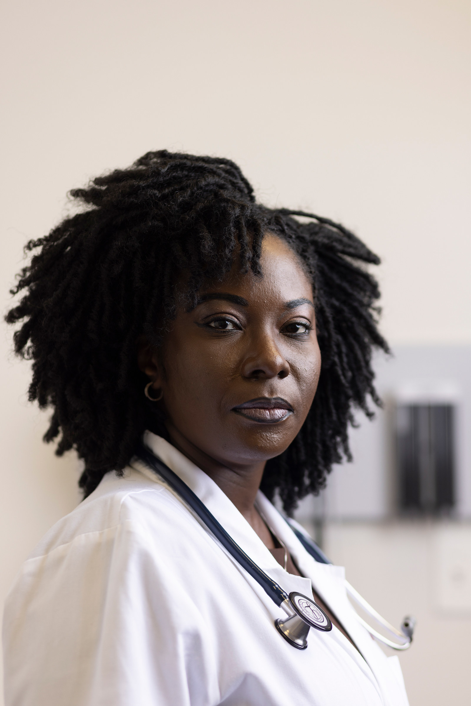 A portrait of Dennar, who is wearing a stethoscope around her neck