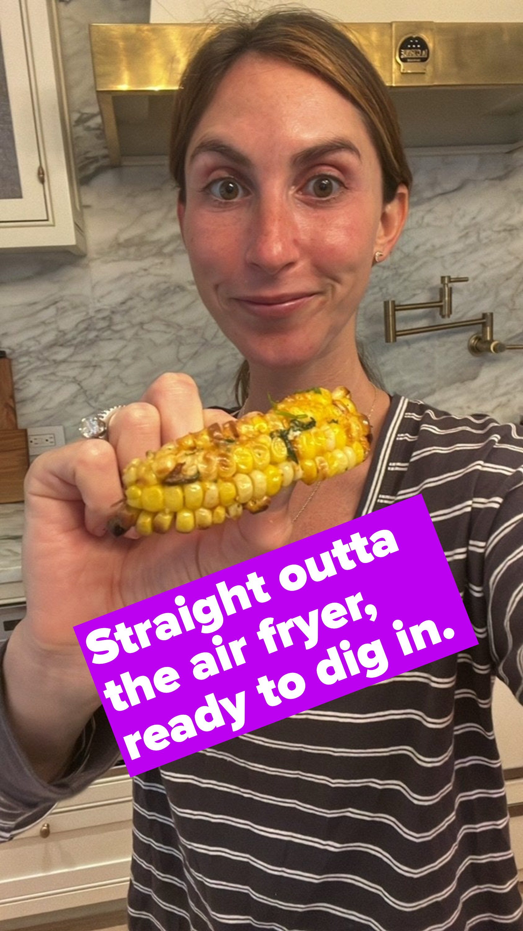A woman holding a piece of charred corn