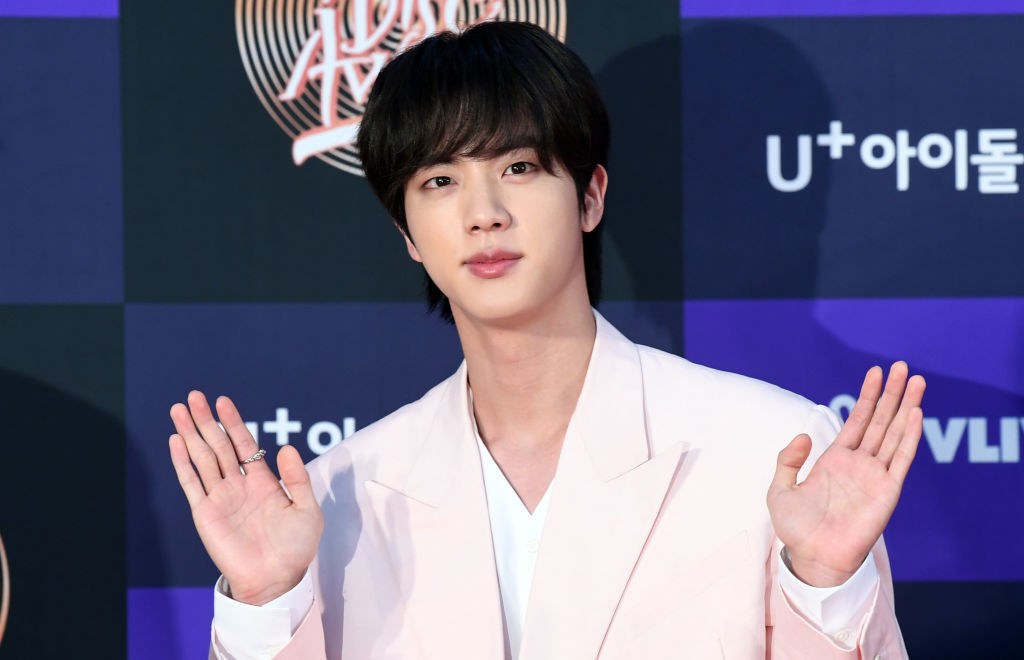 Jin giving waves with both his hands at an event