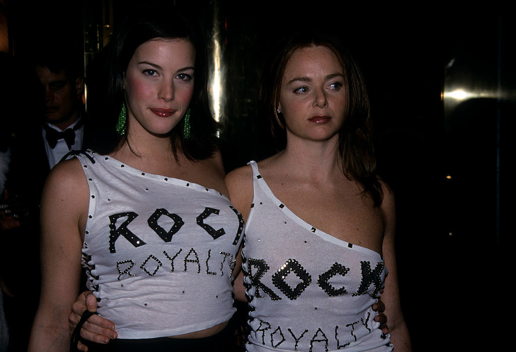 Liv and Stella arm in arm in their one-shouldered &quot;Rock Royalty&quot; undershirts