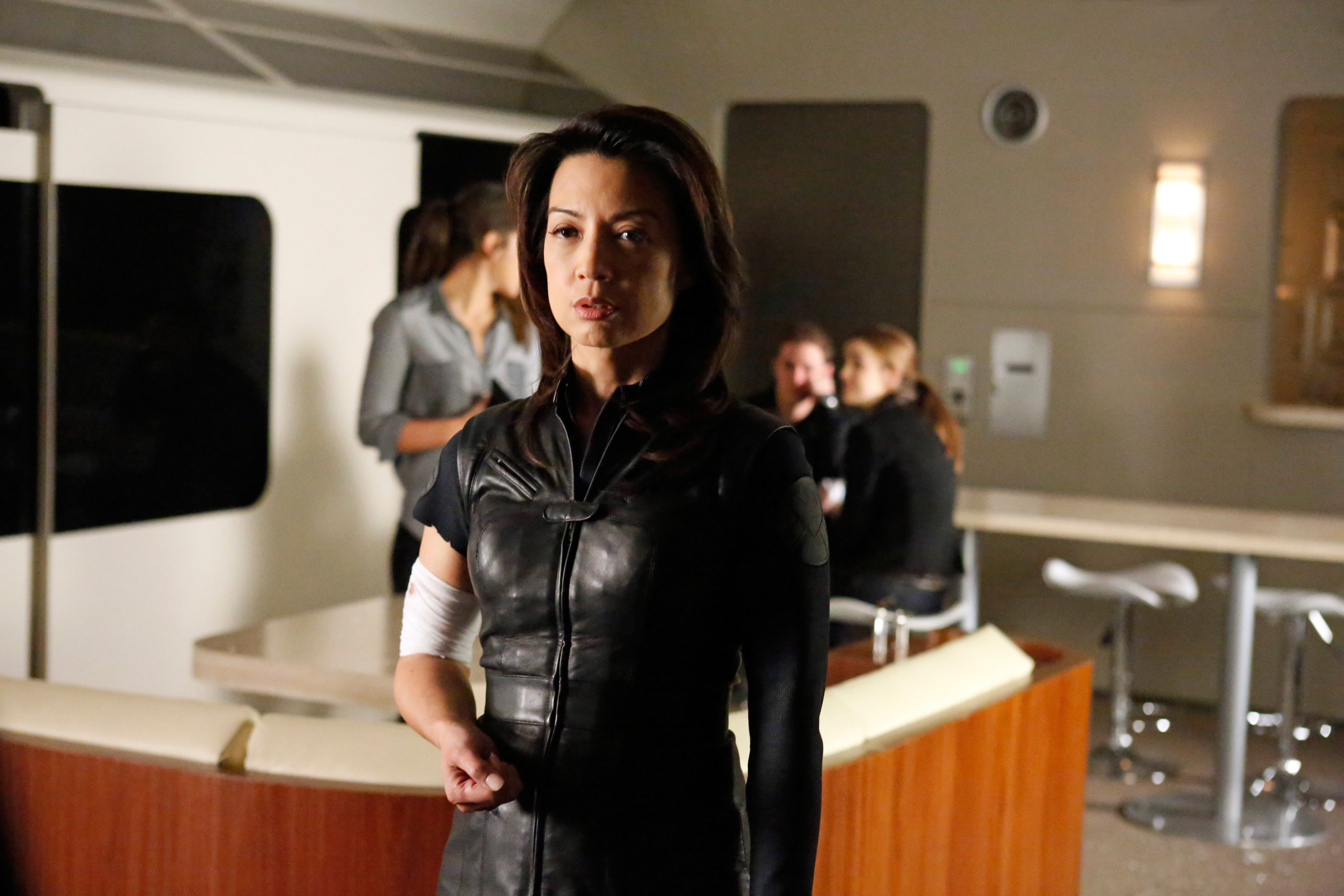 Agent Melinda May in S.H.I.E.L.D. uniform holding a gun