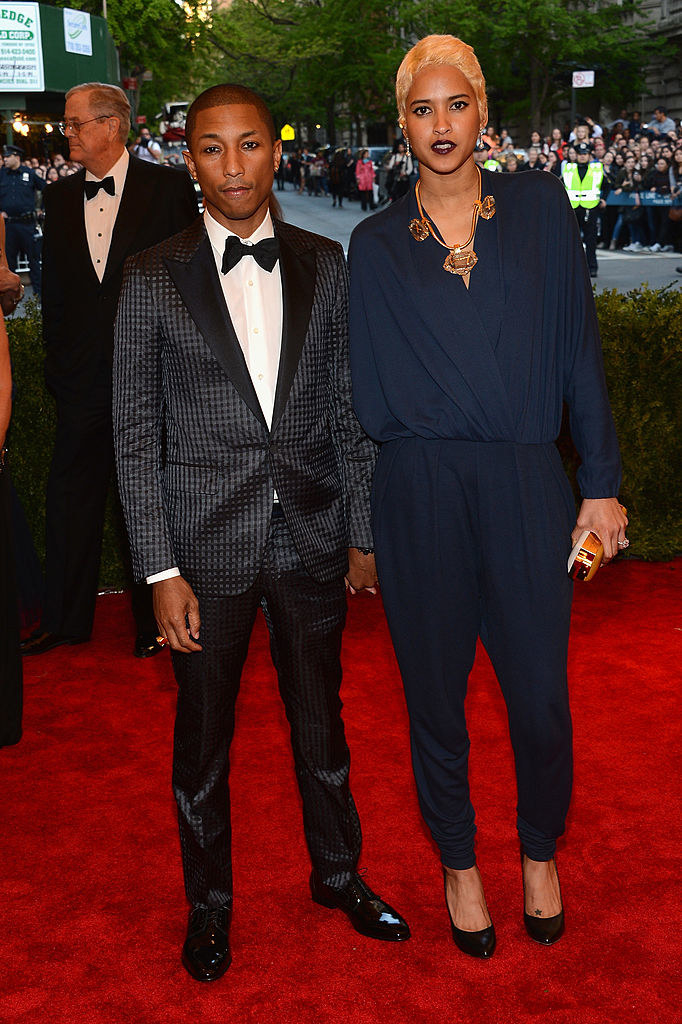Pharrell wearing a checkerboard suit and Helen wearing a blue jumpsuit