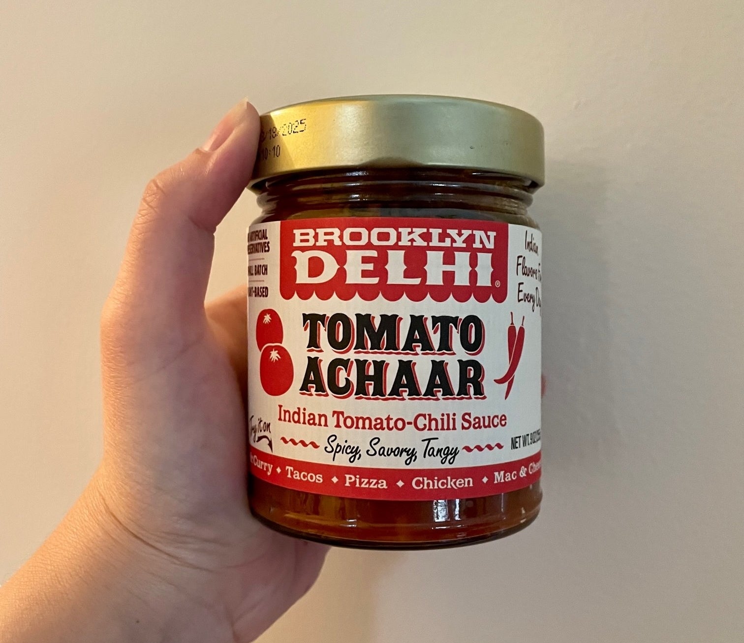 Writer holding up a jar of tomato achaar chili sauce