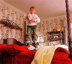 kevin from home alone jumping on a bed