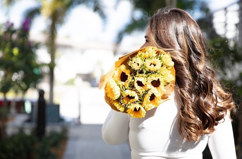 Person holding sunflowers