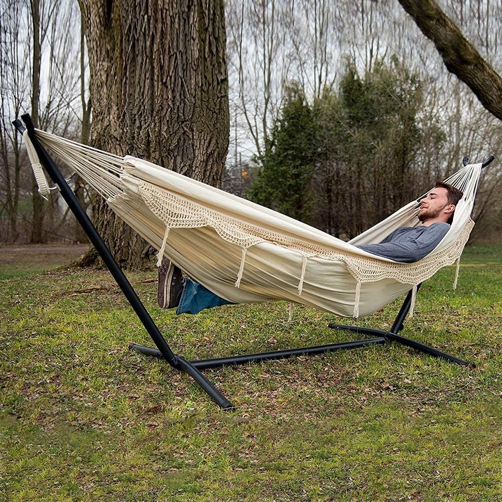 A person sitting in the hammock outdoors