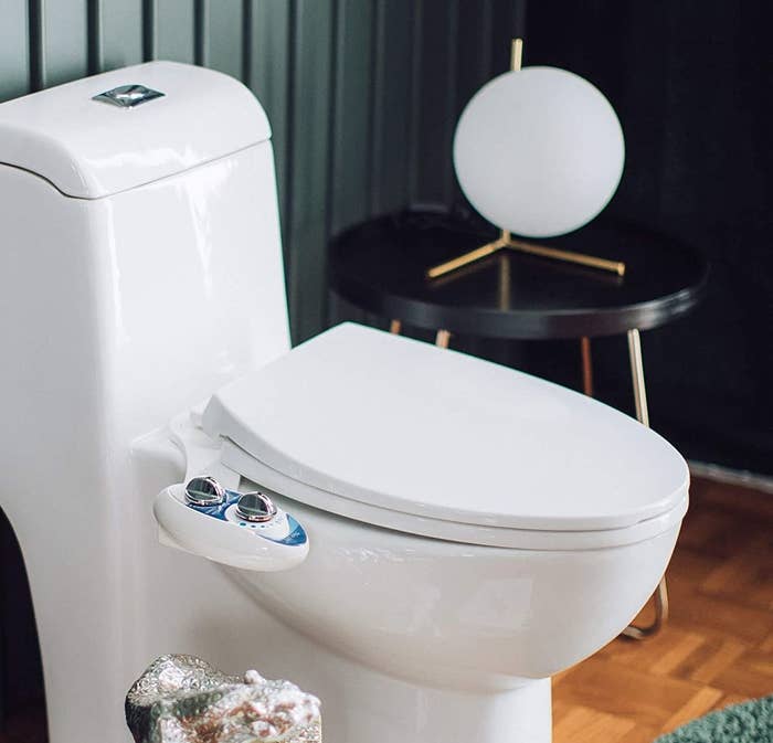 The bidet attached to a toilet in a bathroom