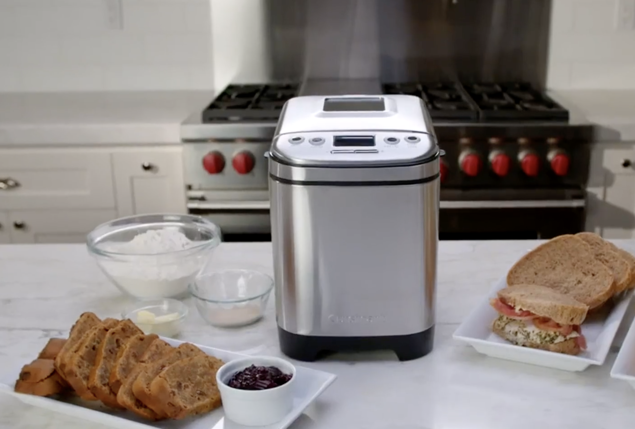 The bread maker on a counter surrounded by bread