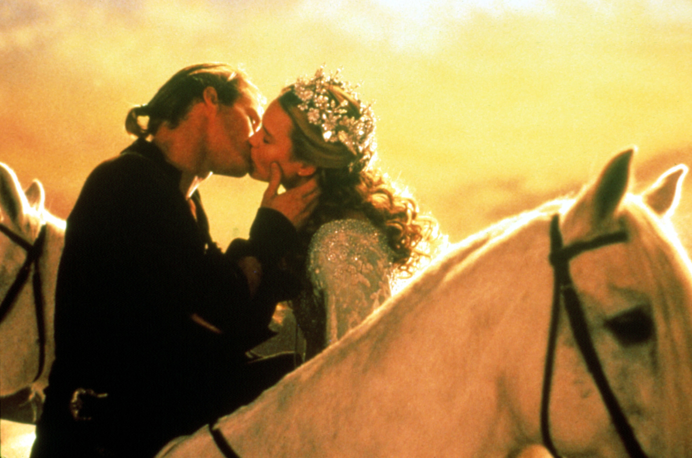 the couple kissing as they sit horseback on their own horses