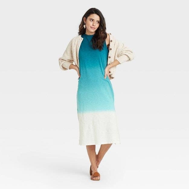 A model wears the blue and white ombre dress with brown sandals and a beige sweater