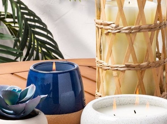 The round ceramic candle on outdoor patio table with other candles and succulent plant