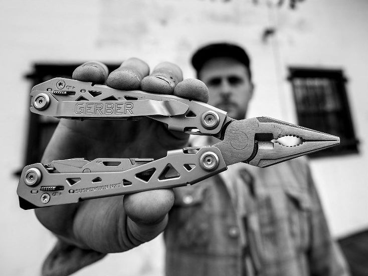 black and white photo of model holding the Gerber tool in the pliers position