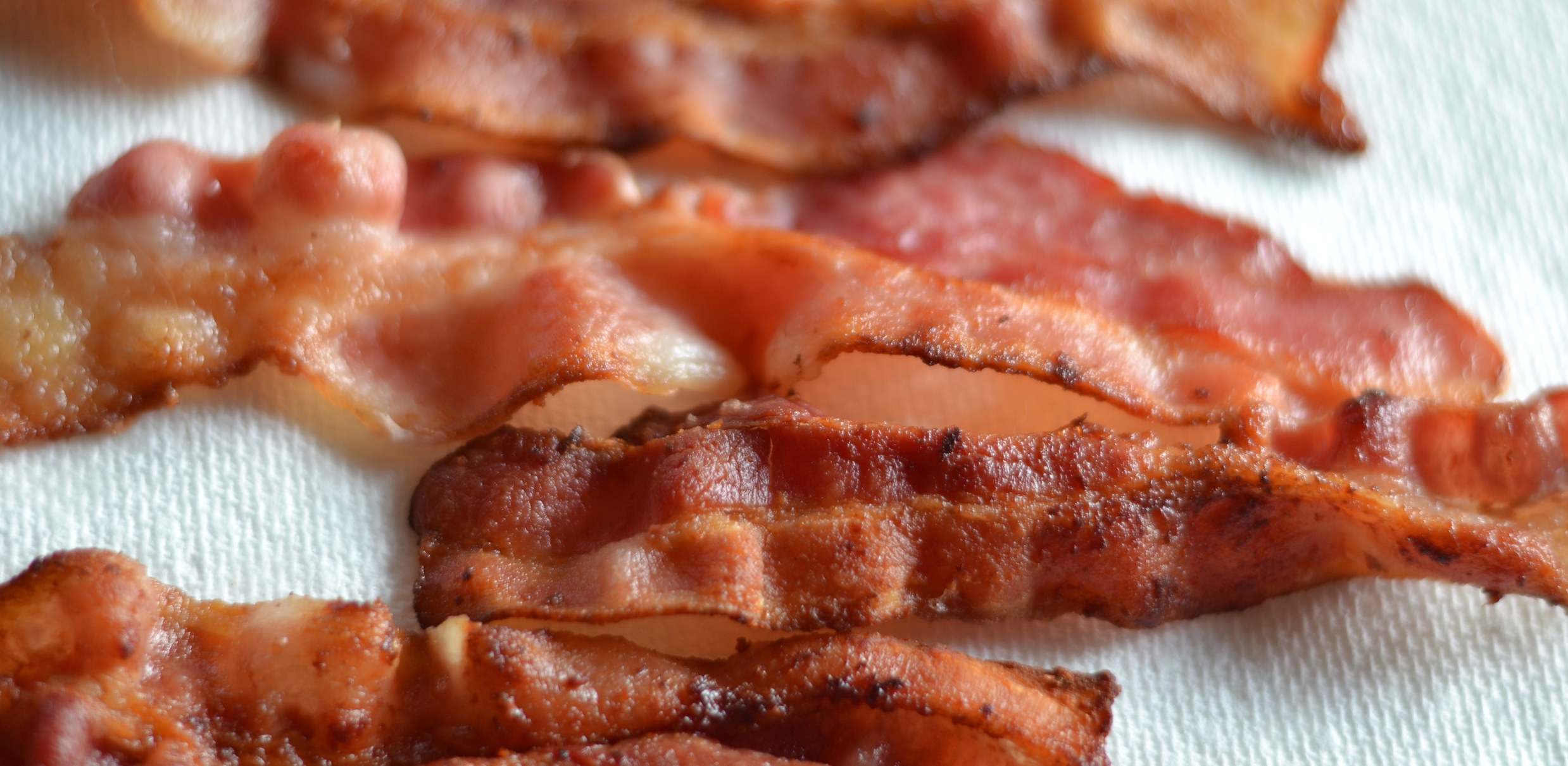 A close-up of fried bacon on paper towel