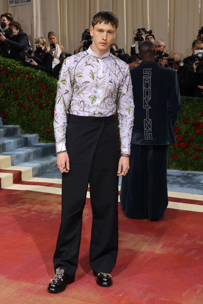 Harris Dickinson in an embroidered, sequined shirt, pants, and matching shoes