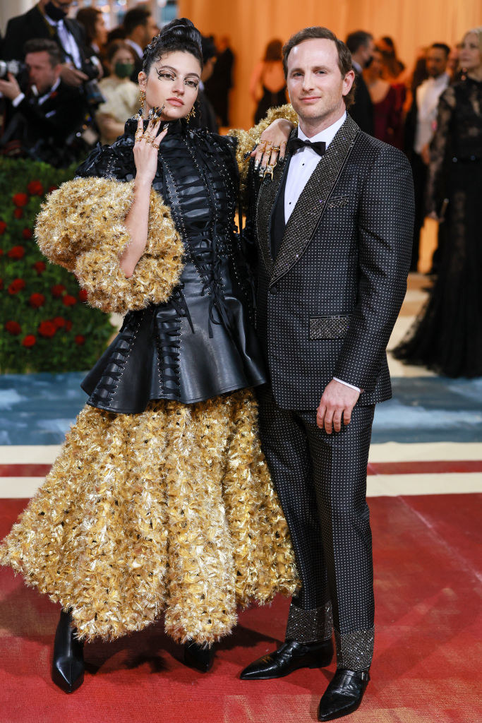 Isabelle Boemeke wearing a gold and leather outfit and Joe Gebbiea in gold and black tux