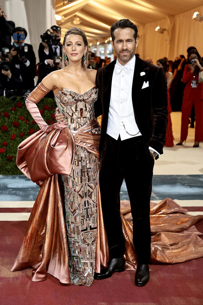 Blake Lively wears a sequined gown with a matching train and Ryan Reynolds wears a tux