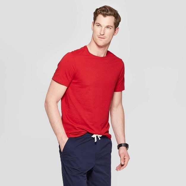 The model wears the red shirt and navy bottoms