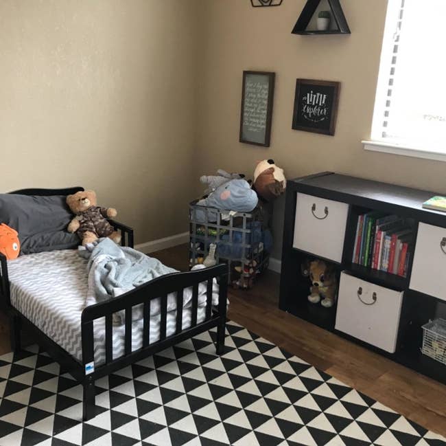 reviewer's photo of the toddler bed in the black and white themed kid's room