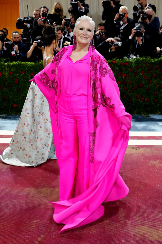 Glenn Close in a pink suit with a cape that has a long cape