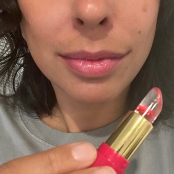 the same editor holding the tube of lip stain and showing how pretty it looks