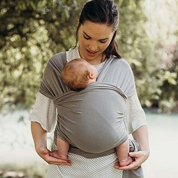 A model wearing a baby in the grey wrap