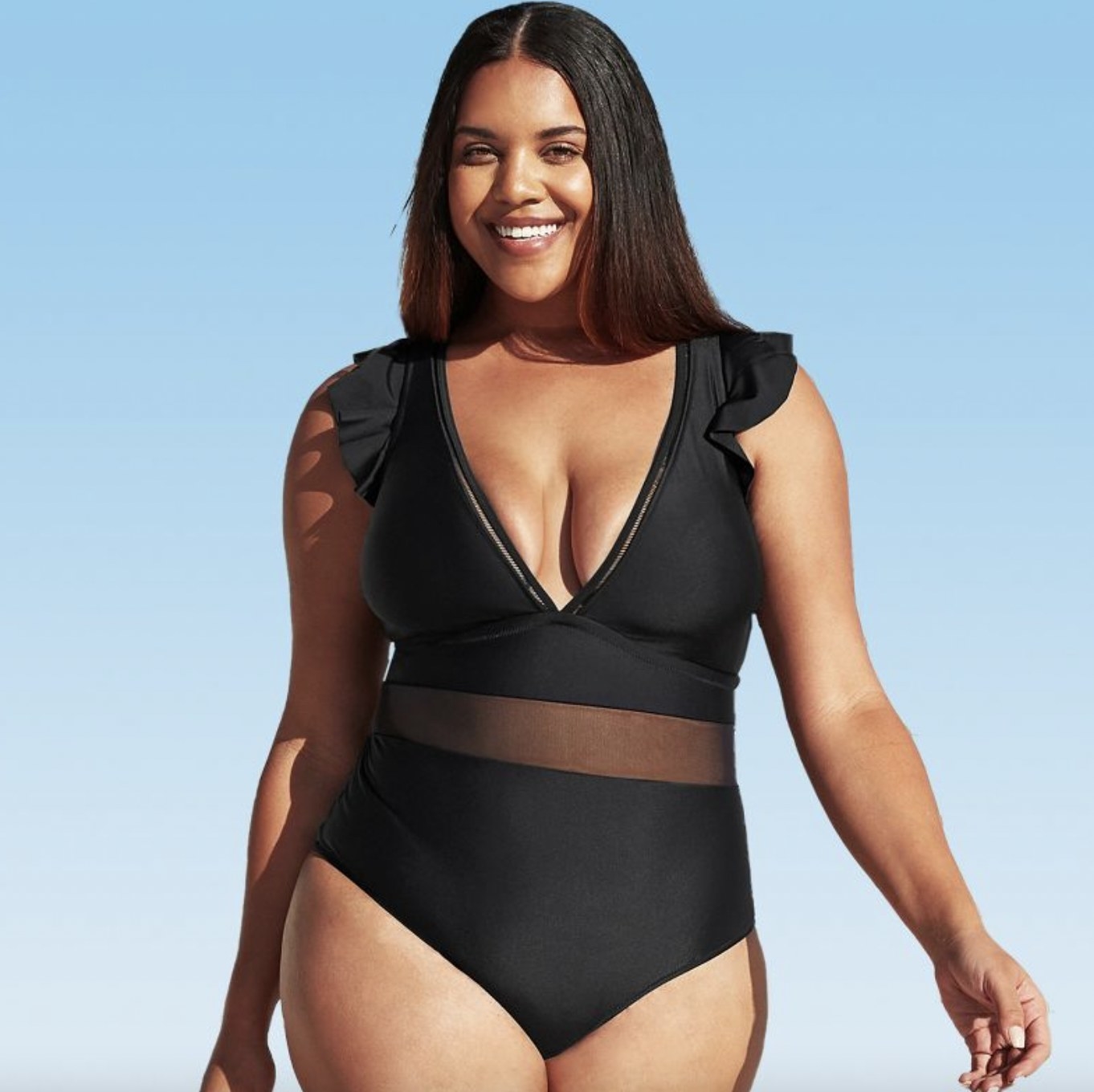 A person wearing a black V-neck one-piece swimsuit