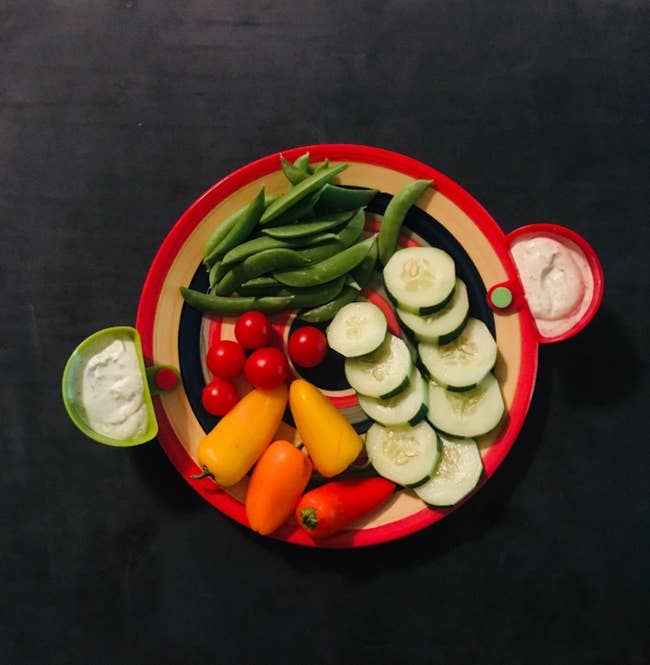 reviewer image of two dip clips on the side of a plate with veggies on it
