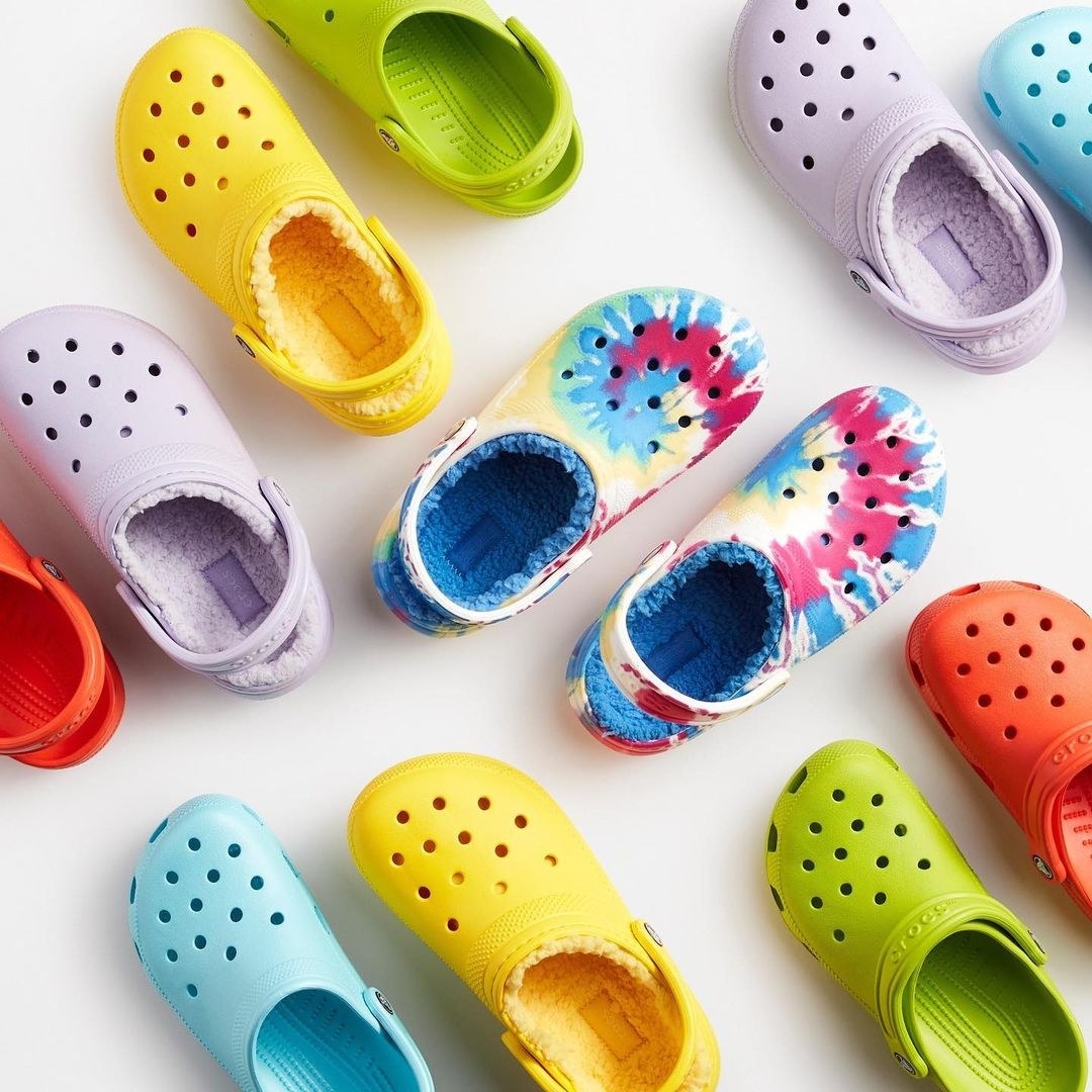a flatlay of several colourful pairs of the sherpa-lined crocs