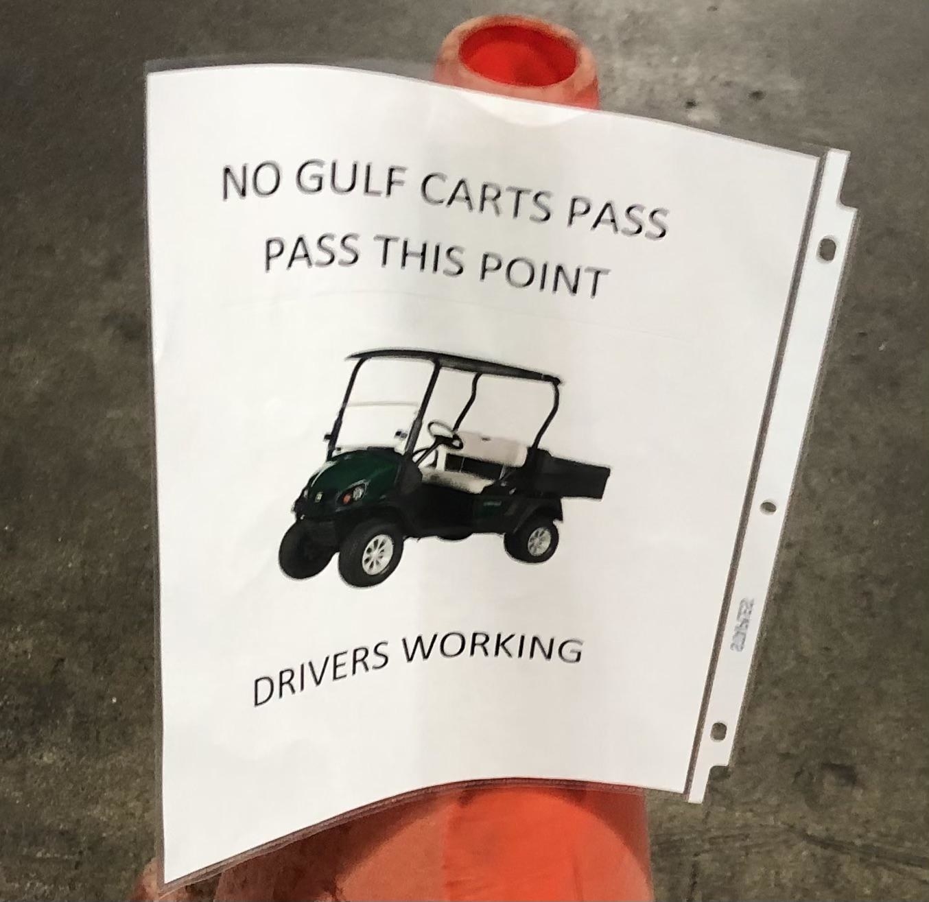 Sign that says, &quot;No gulf carts pass pass this point drivers working&quot;